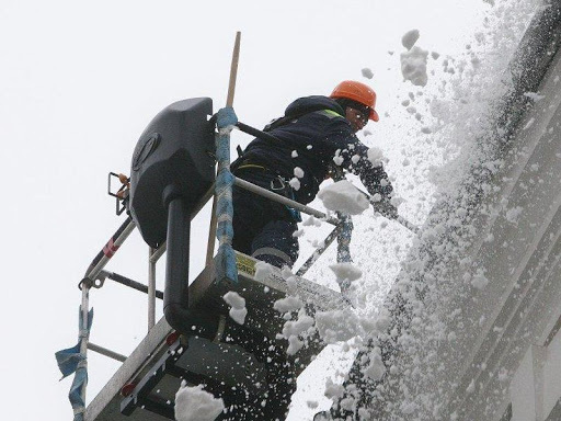 Фото процесса удаление наледи с крыши с помощью автовышки