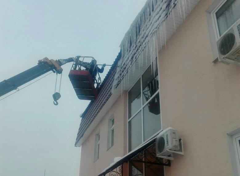 Фото процесса удаления сосулек с круши жилого дома в Туле